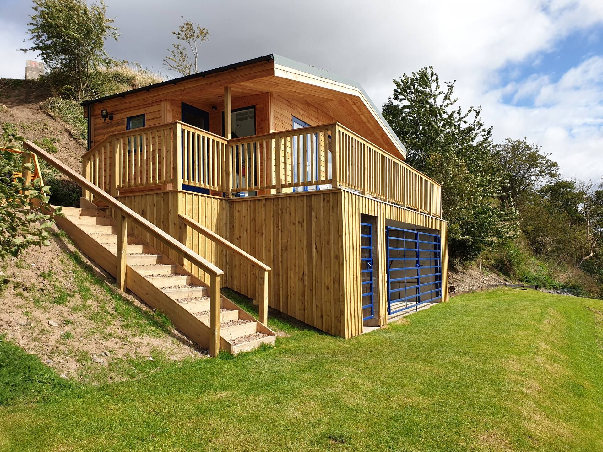 The timber fishing hut at Upper North Wark with its balcony and steps up from the lawn